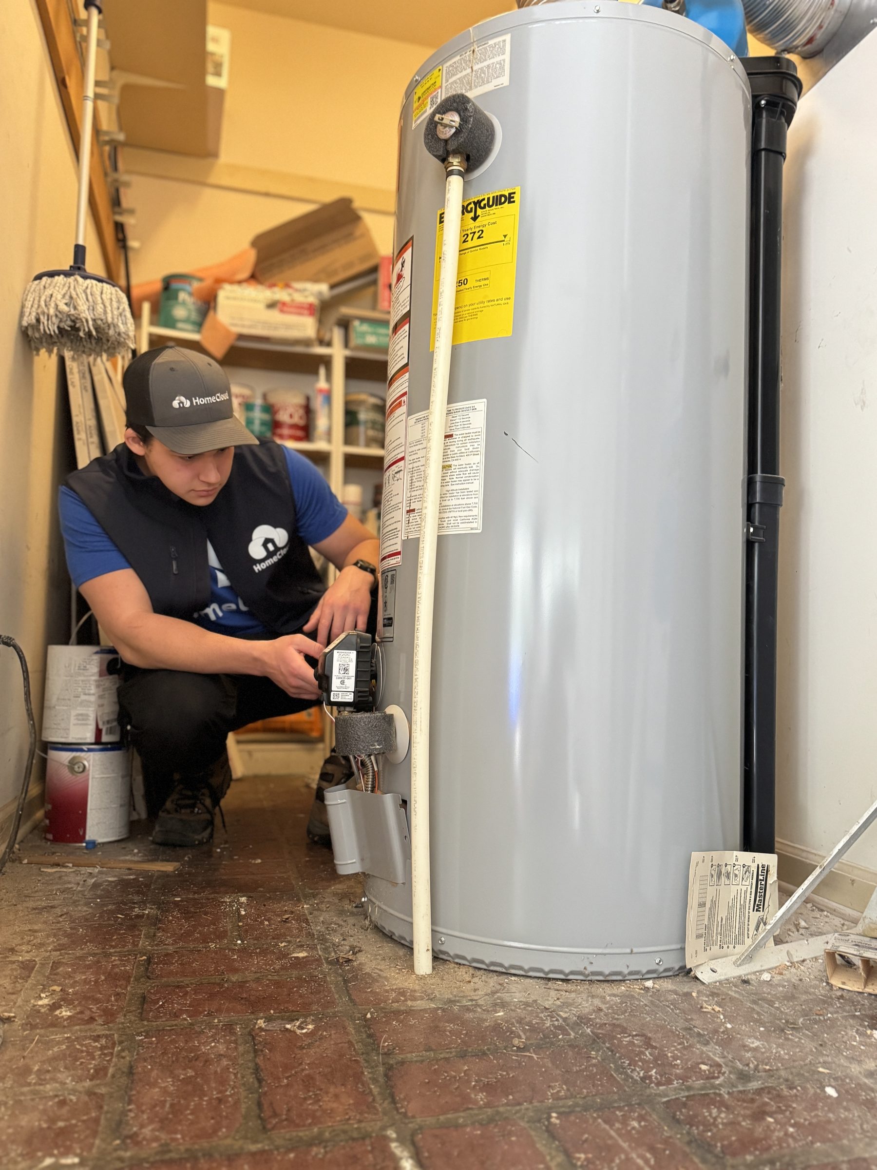 A HomeCloud team member working beside a water heater